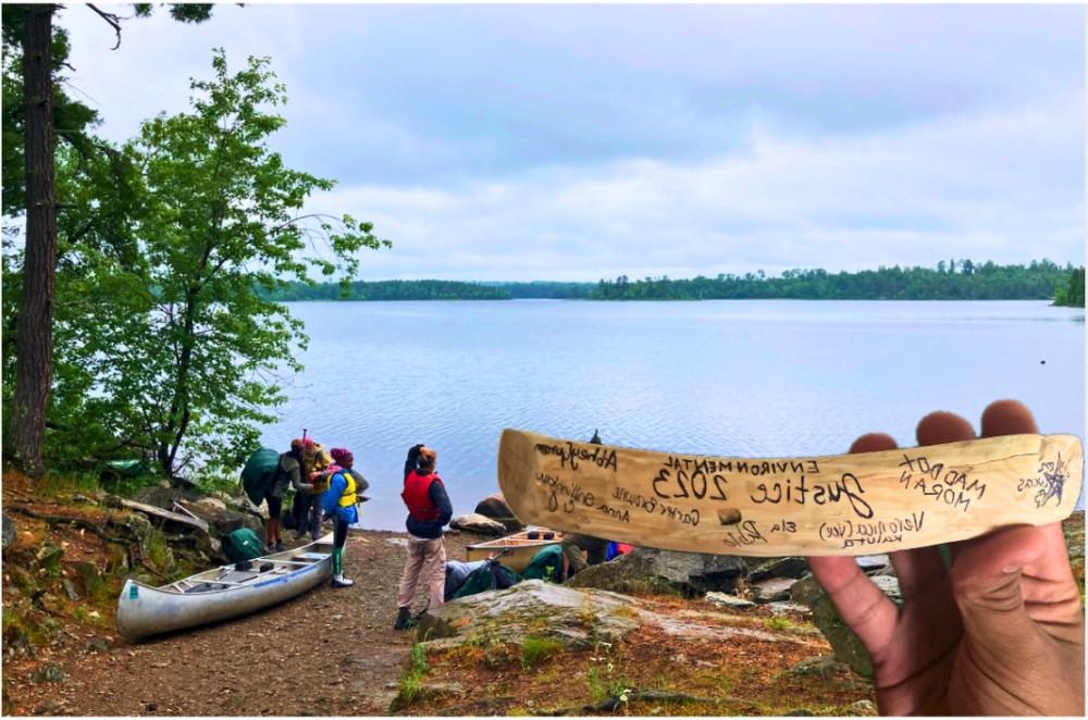 Abhey resting at a portage with a signed memento from the trip.